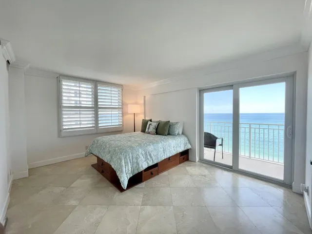 a spacious bedroom with a bed and a large window