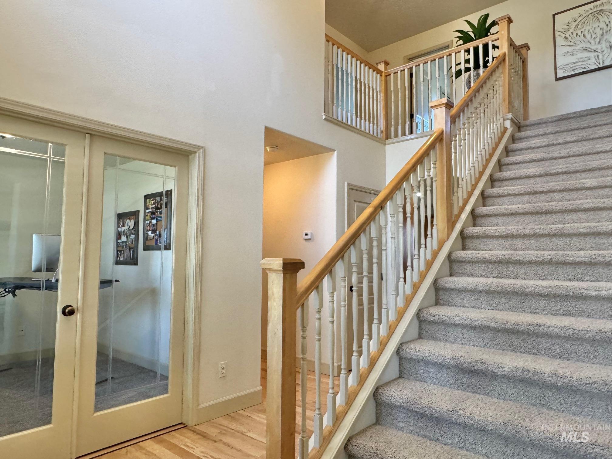 9299 Kemp Road Middleton, ID 83644 - Photo 22 of 50 Grayscale carpeted staircase with natural wood banister and balusters