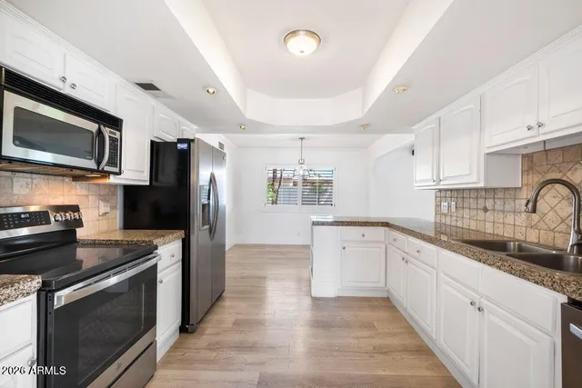 a kitchen with granite countertop stainless steel appliances cabinets a sink and a counter space