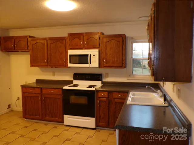 a kitchen with stainless steel appliances granite countertop a stove a sink and a microwave