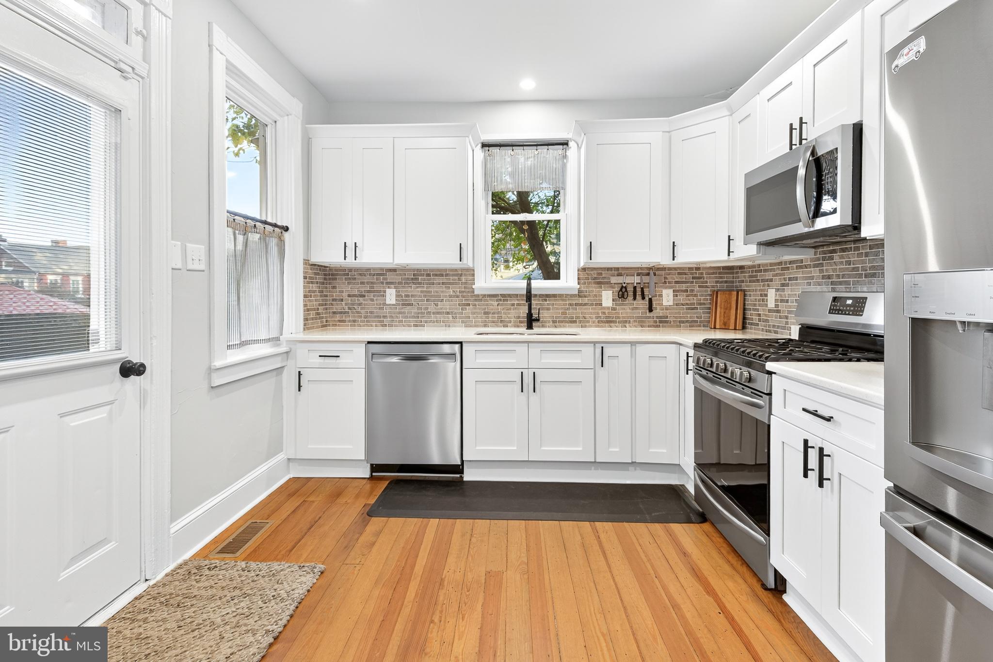 624 St Joseph Street Lancaster, PA 17603 - Photo 14 of 44 a kitchen with stainless steel appliances granite countertop a stove top oven a sink dishwasher and a refrigerator with wooden floor
