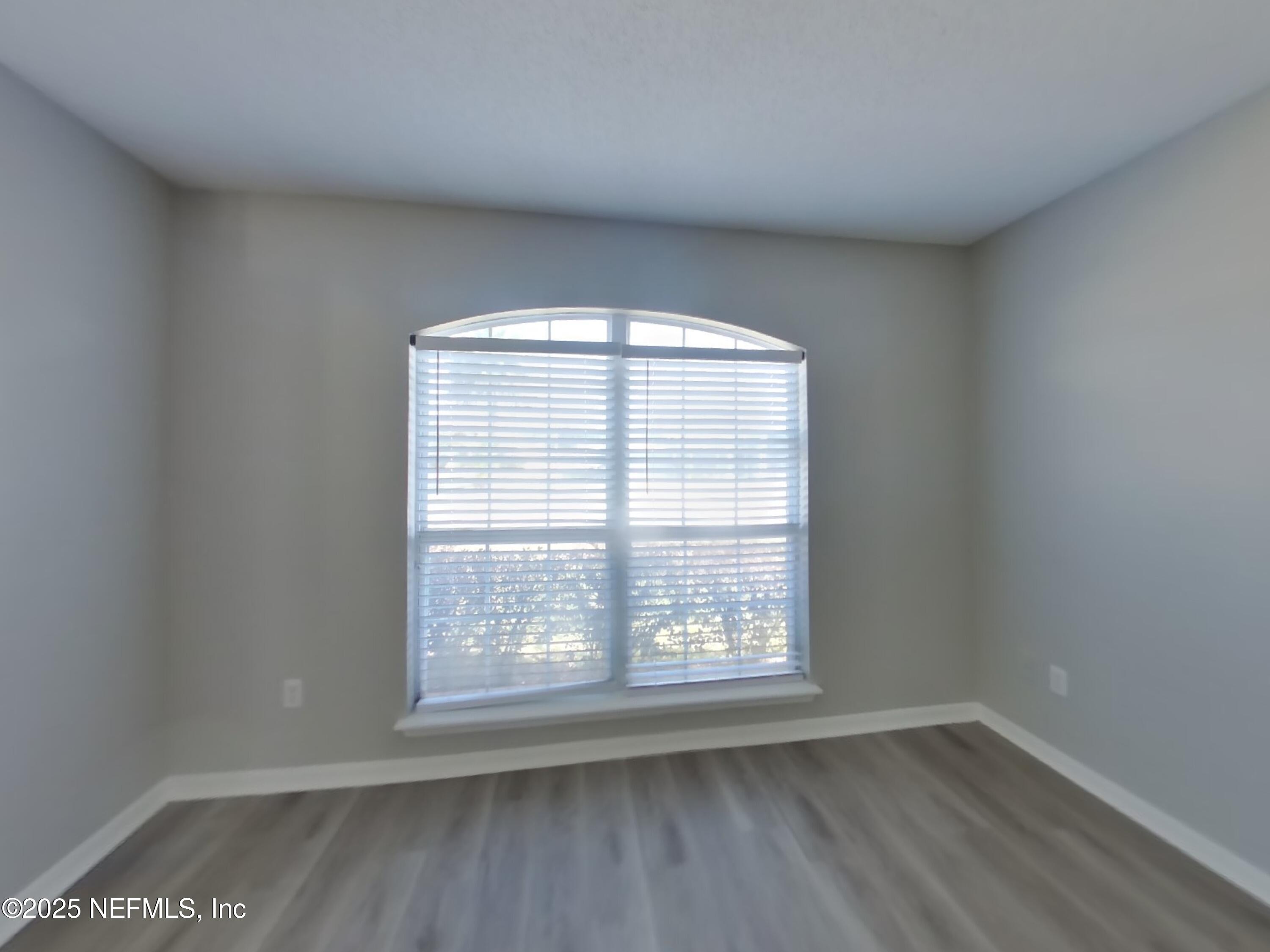 984 Fox Chapel Lane Jacksonville, FL 32221 - Photo 14 of 15 an empty room with wooden floor and windows