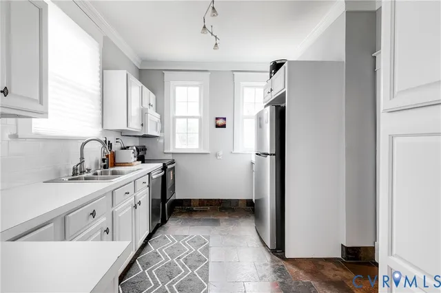 a kitchen with a refrigerator a sink and cabinets