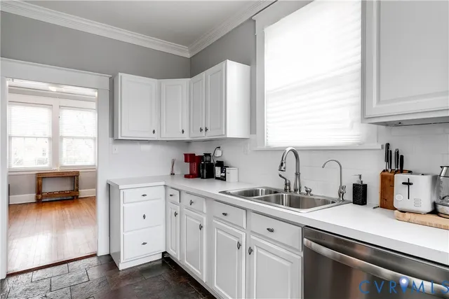 a kitchen with cabinets appliances a sink and a window