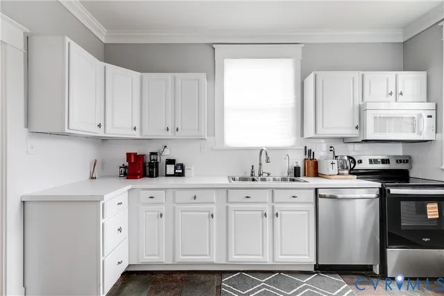 a kitchen with white cabinets white stainless steel appliances and sink