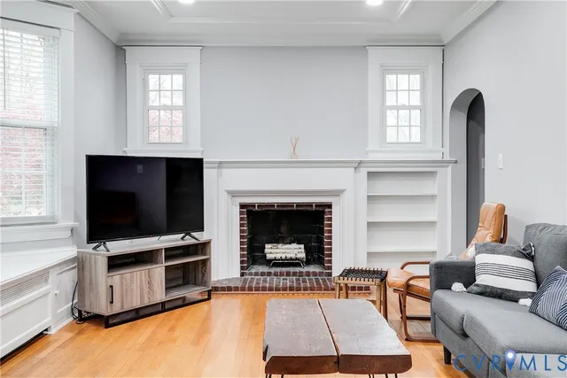 a living room with furniture a flat screen tv and a fireplace