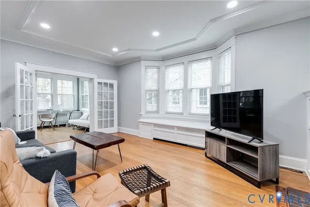 a living room with furniture a flat screen tv and a window
