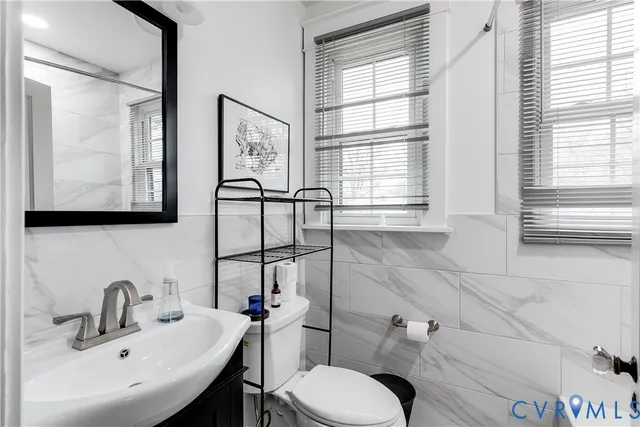 a bathroom with a toilet sink and mirror