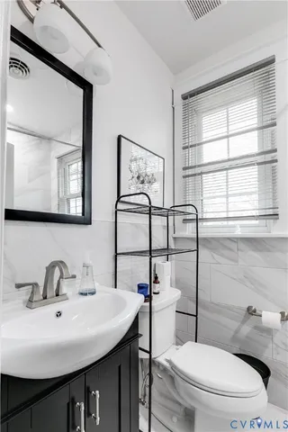 a bathroom with a sink a toilet and mirror