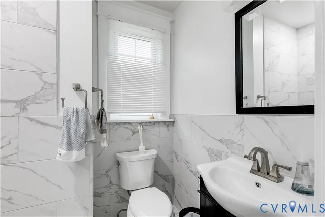 a bathroom with a sink mirror and toilet