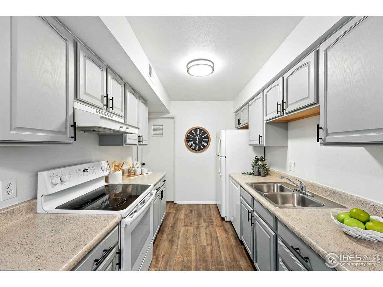 9857 Lane Street Thornton, CO 80260 - Photo 15 of 38 a kitchen that has a lot of cabinets a sink and wooden floor
