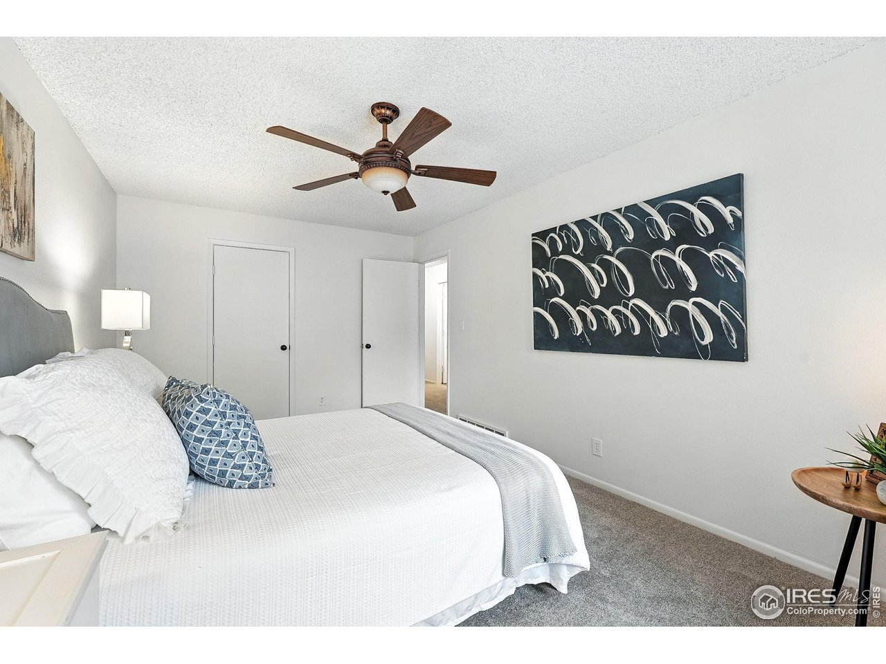 9857 Lane Street Thornton, CO 80260 - Photo 20 of 38 a bedroom with a large bed and a chandelier