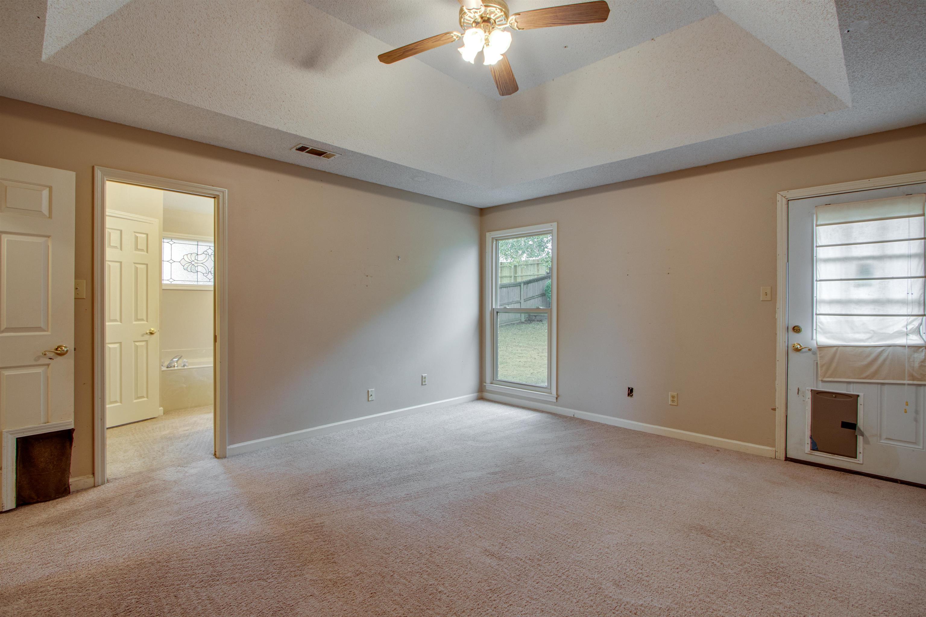690 Ridge Fall Drive Memphis, TN 38018 - Photo 22 of 28 an empty room with windows and chandelier fan