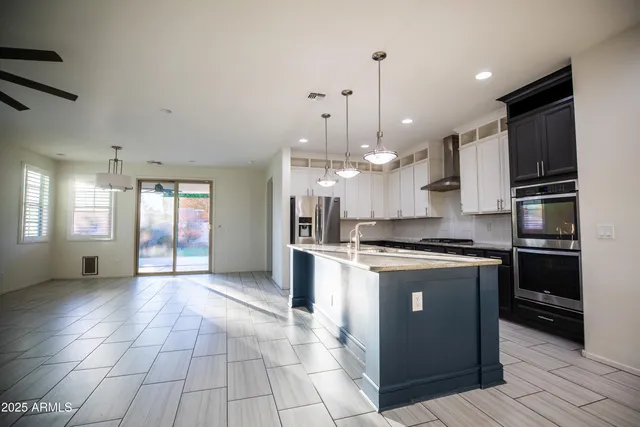 a large kitchen with stainless steel appliances granite countertop a stove and a refrigerator