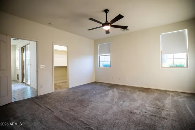 a view of a big room with wooden floor and windows