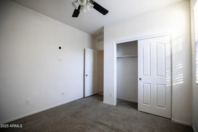an empty room with closet and windows