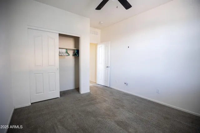 an empty room with closet and windows