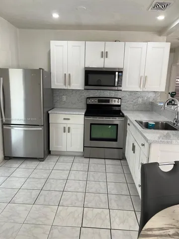 a kitchen with a stove top oven and cabinets