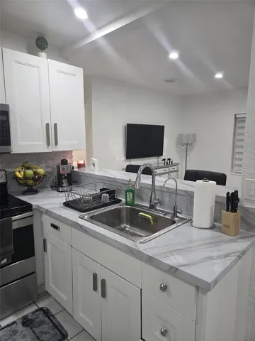 a kitchen with sink a stove and cabinets