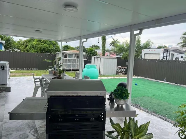 a view of a patio with table and chairs potted plants with floor to ceiling window yard