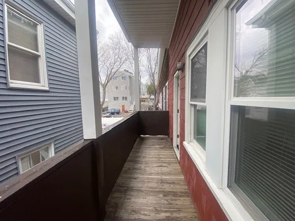 a view of a balcony with wooden floor and floor to ceiling window