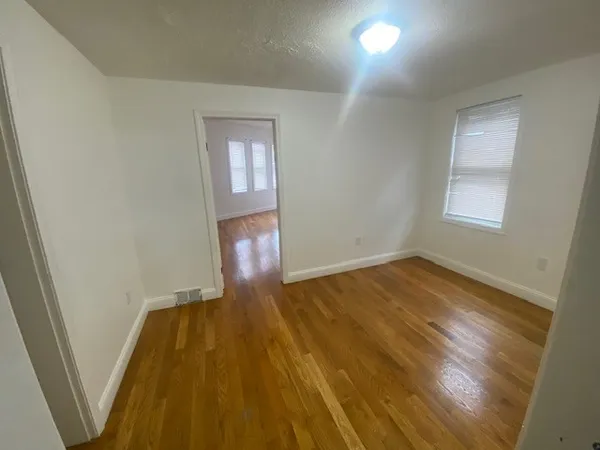 wooden floor in an empty room with a mirror