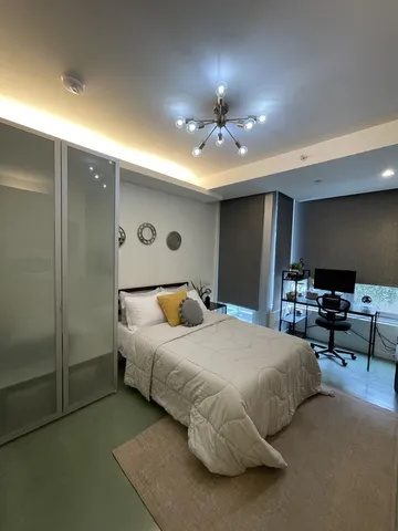 a spacious bedroom with a bed and a chandelier