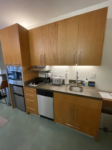 a kitchen with stainless steel appliances granite countertop wooden cabinets a sink and a stove