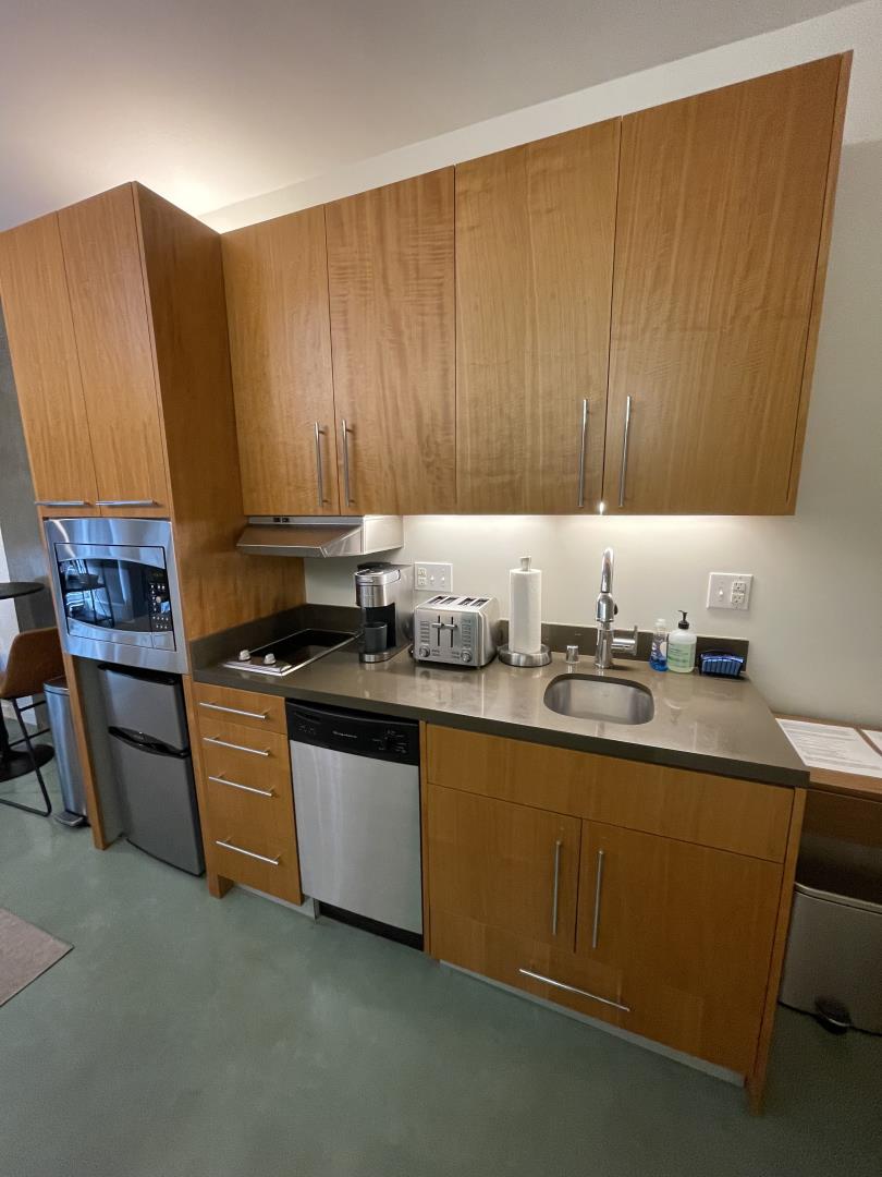 766 Harrison Street, Unit 202 San Francisco, CA 94107 - Photo 3 of 4 a kitchen with stainless steel appliances granite countertop wooden cabinets a sink and a stove