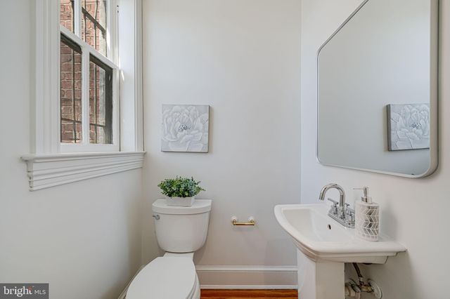 a kitchen with a sink a refrigerator and white cabinets