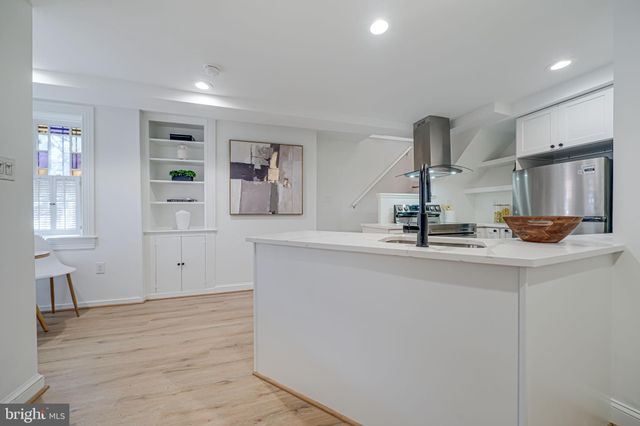 a kitchen with kitchen island a sink and a stove with wooden floor
