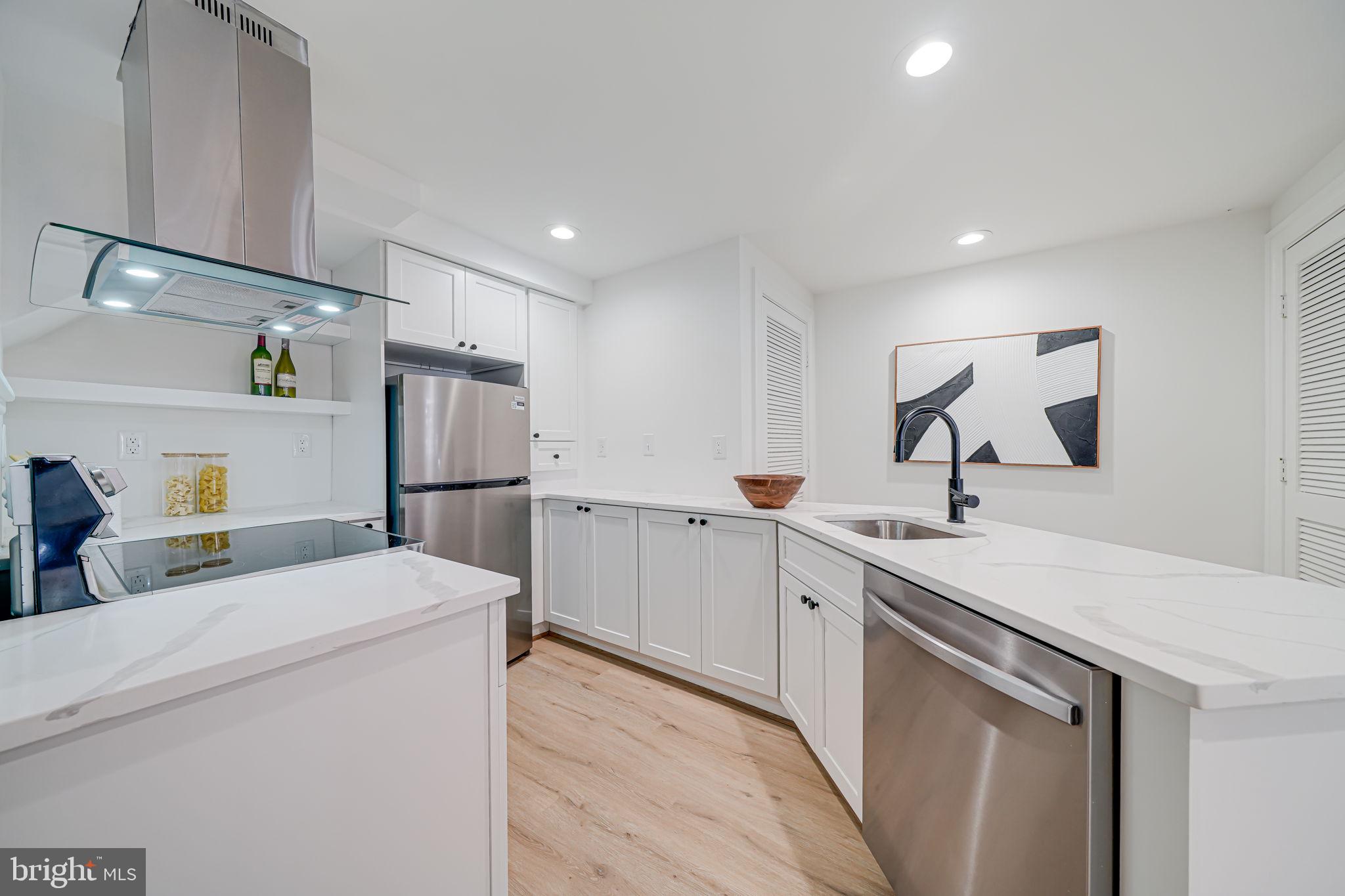 106 3rd Street Northeast Washington, DC 20002 - Photo 14 of 63 a kitchen with a sink a refrigerator and white cabinets