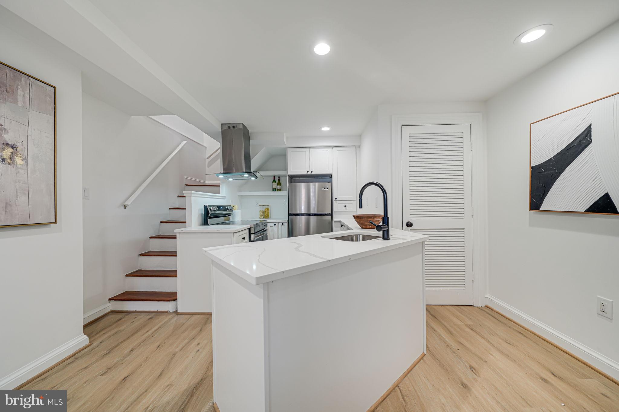 106 3rd Street Northeast Washington, DC 20002 - Photo 16 of 63 a kitchen with kitchen island a sink and a stove with wooden floor