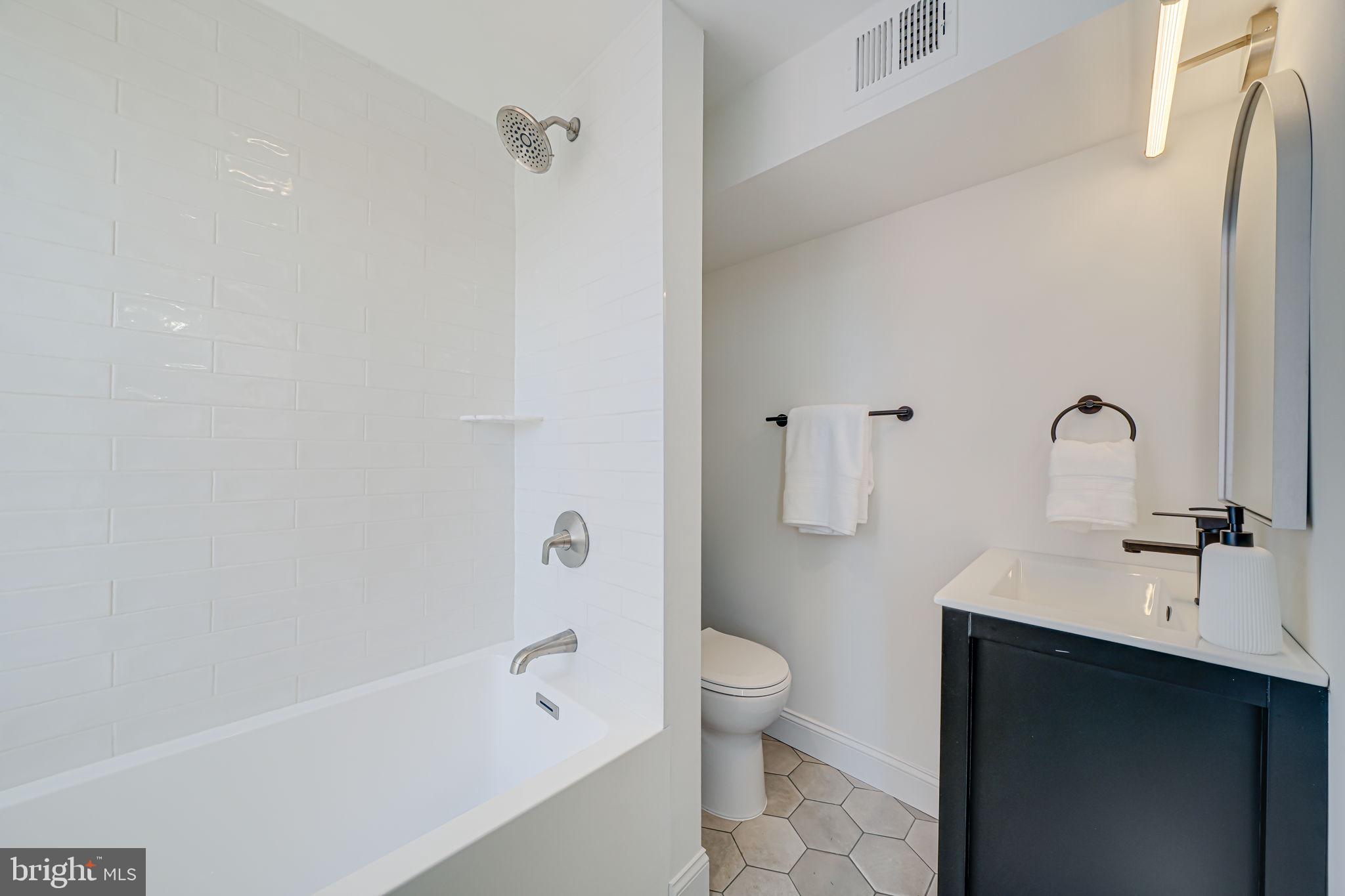 106 3rd Street Northeast Washington, DC 20002 - Photo 33 of 63 a bathroom with a bathtub sink vanity mirror and toilet