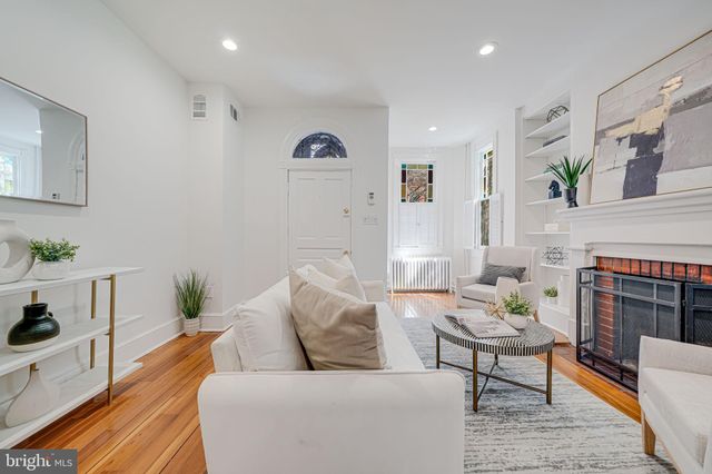a living room with furniture a fireplace and a potted plant
