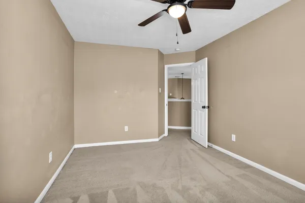 an empty room with an empty space and chandelier fan