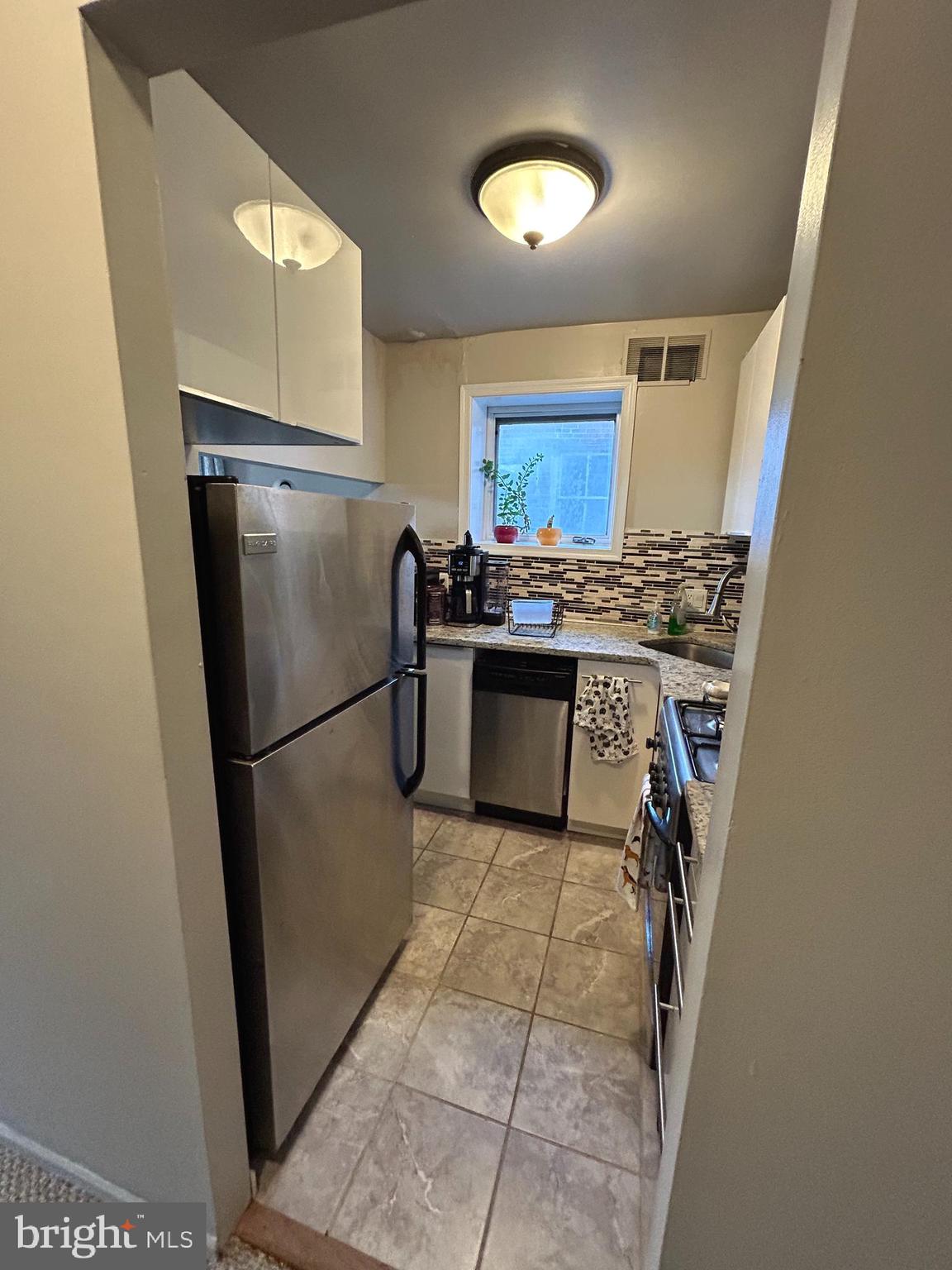 937 Spruce Street Philadelphia, PA 19107 - Photo 30 of 80 a kitchen with stainless steel appliances granite countertop a refrigerator a stove a sink a washer dryer and a refrigerator