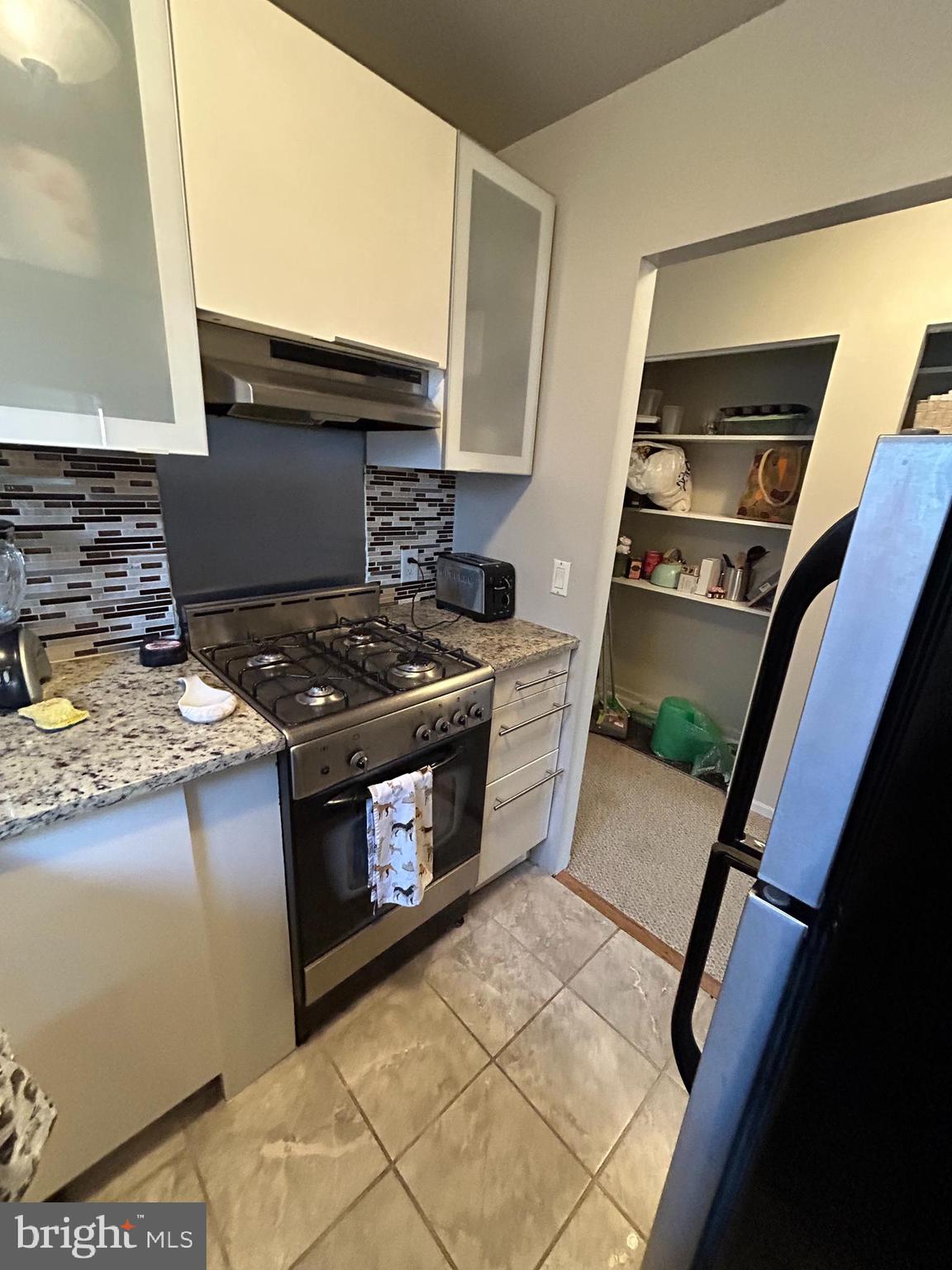 937 Spruce Street Philadelphia, PA 19107 - Photo 34 of 80 a kitchen with granite countertop a stove and a refrigerator