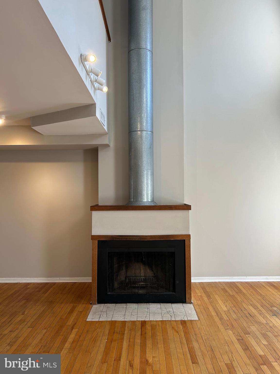 937 Spruce Street Philadelphia, PA 19107 - Photo 72 of 80 a view of an empty room with wooden floor and a fireplace