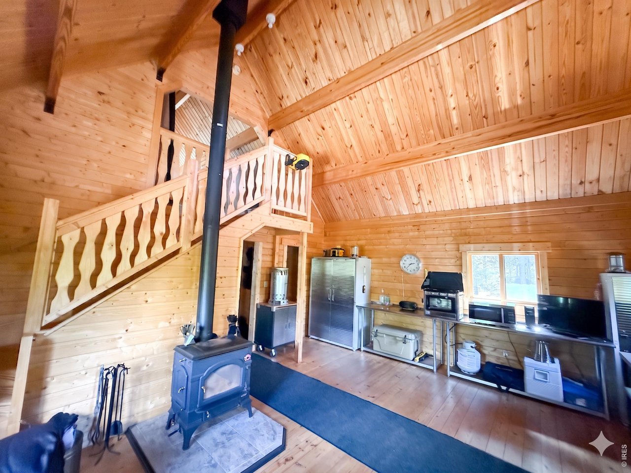 10000 Forest Road, Unit 169 Red Feather Lakes, CO 80545 - Photo 5 of 31 Enjoy the warmth of golden pine and soaring ceilings in this inviting room with kitchen and wood-burning stove.