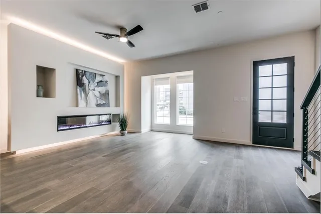 an empty room with windows and ceiling fan