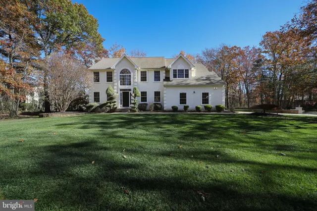 a white house with a big yard and trees