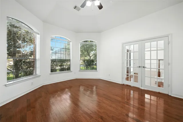 a view of an empty room with wooden floor and staircase