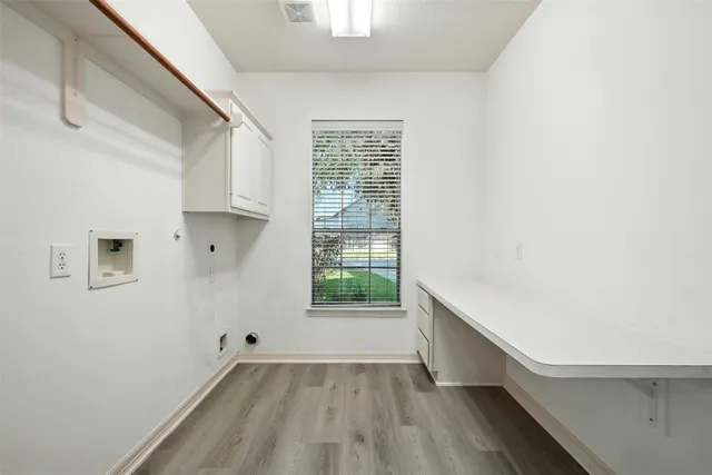 a open kitchen with granite countertop a stove top oven a sink dishwasher and white cabinets with wooden floor