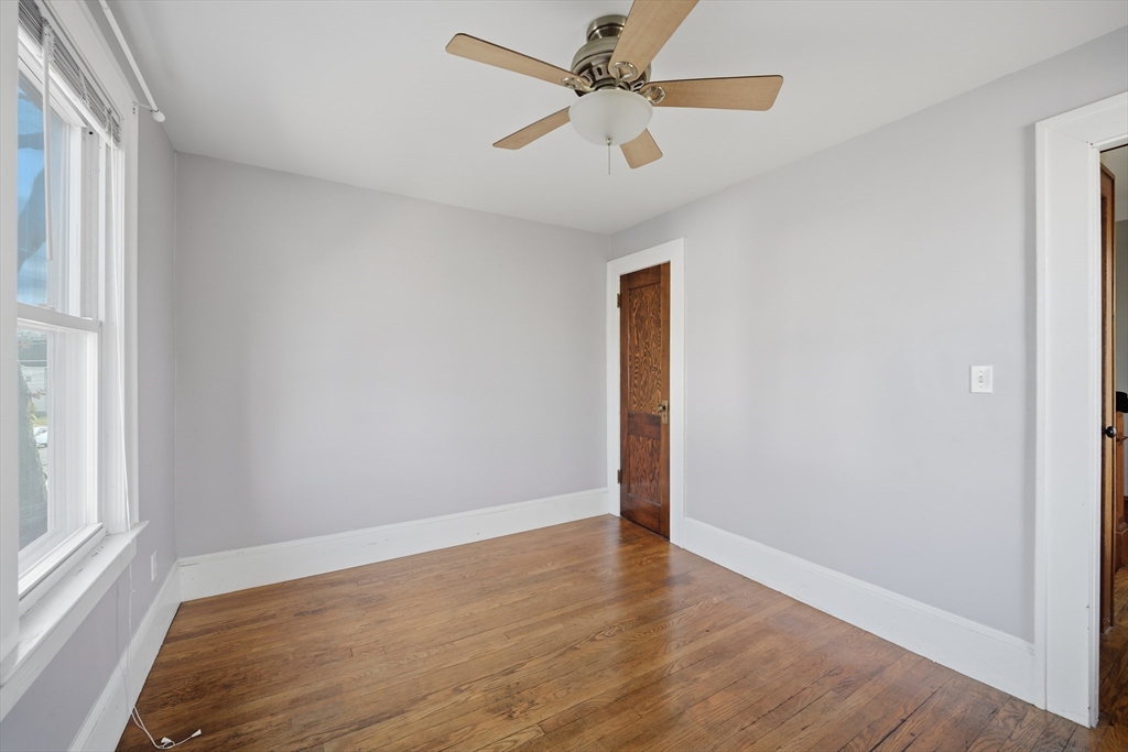 572 Springfield Street Chicopee, MA 01013 - Photo 23 of 42 an empty room with wooden floor fan and windows