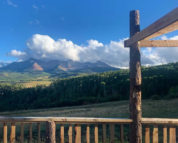a view of a wooden balcony with a yard