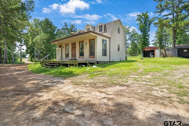 a view of a house with backyard and sitting area