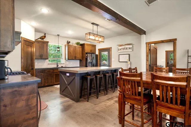 a kitchen with kitchen island granite countertop wooden cabinets and dining table