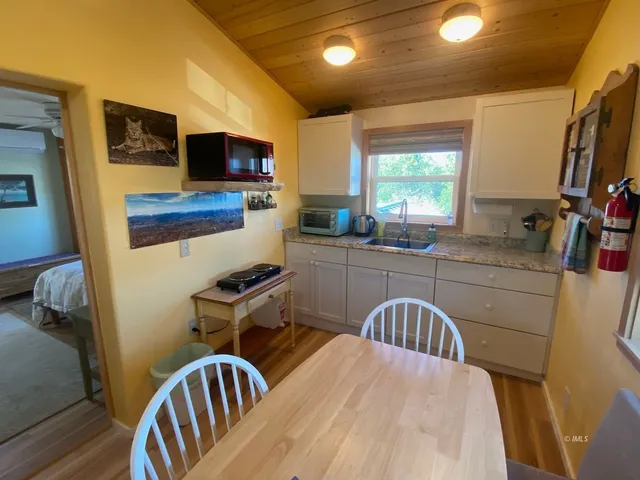 a kitchen with a table chairs sink and microwave