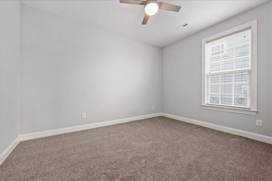 102 Ripplestone Way Anderson, SC 29621 - Photo 16 of 39 A well-lit bedroom features plush carpeting, a wide window for abundant light, and a modern ceiling fan for comfort.